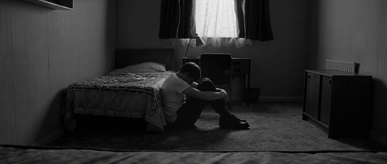 Man sitting quietly, reflecting on the weight of emotions he was taught to hold in silence